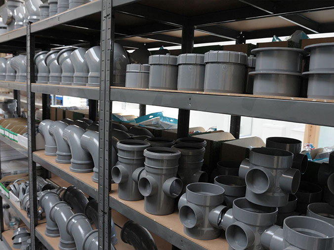 Grey PVC fittings on a shelf in a plumbing warehouse